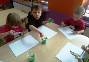 Dzieci malują dłonie farbą